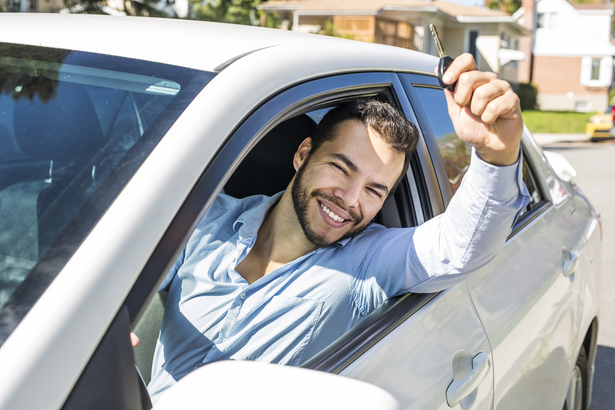 A Closeup portrait, young cheerful, joyful, smiling, men holding up keys to her first new car