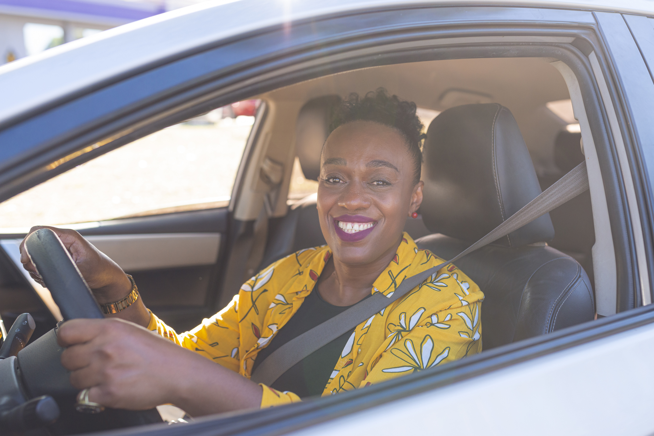 Portrait of smiling lady inside the car.